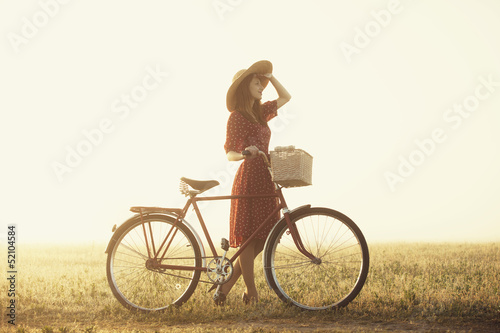 Girl on a bike in the countryside in sunrise time