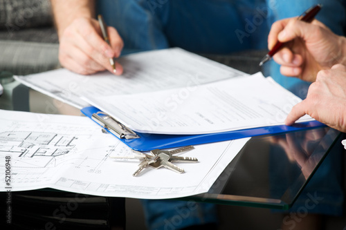 Two people signing a document