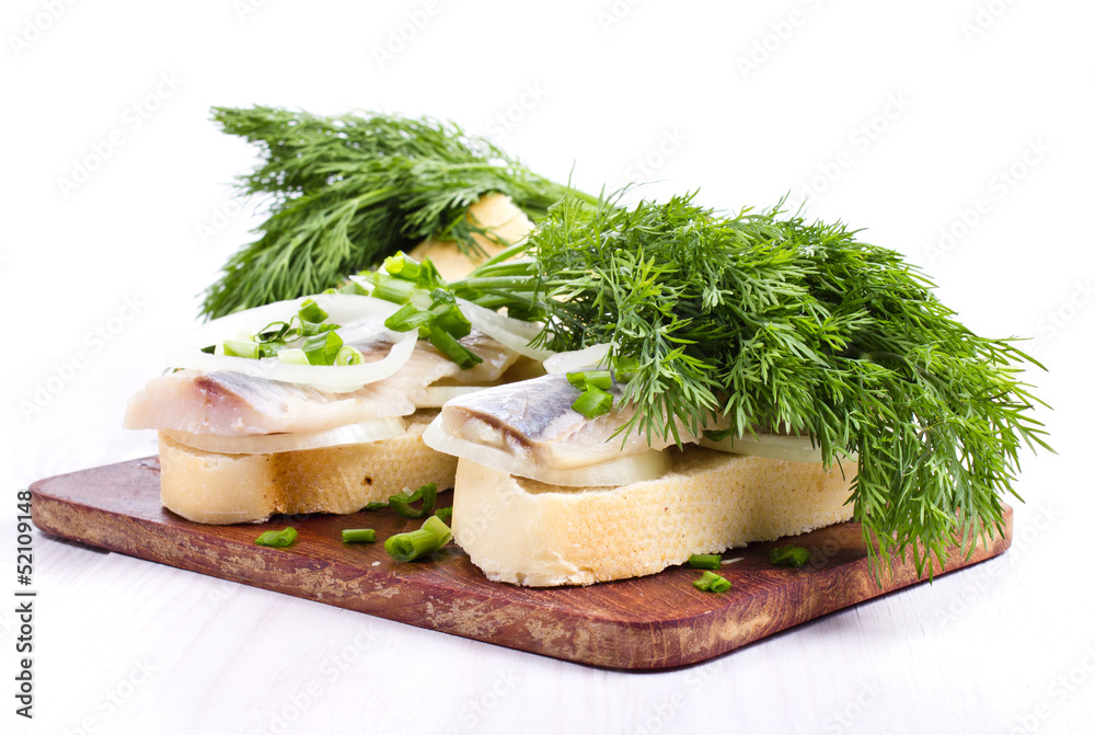 Sandwiches with herring, onions and herbs on white background