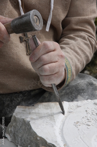 stonemason with ancient costume during the processing of the sto