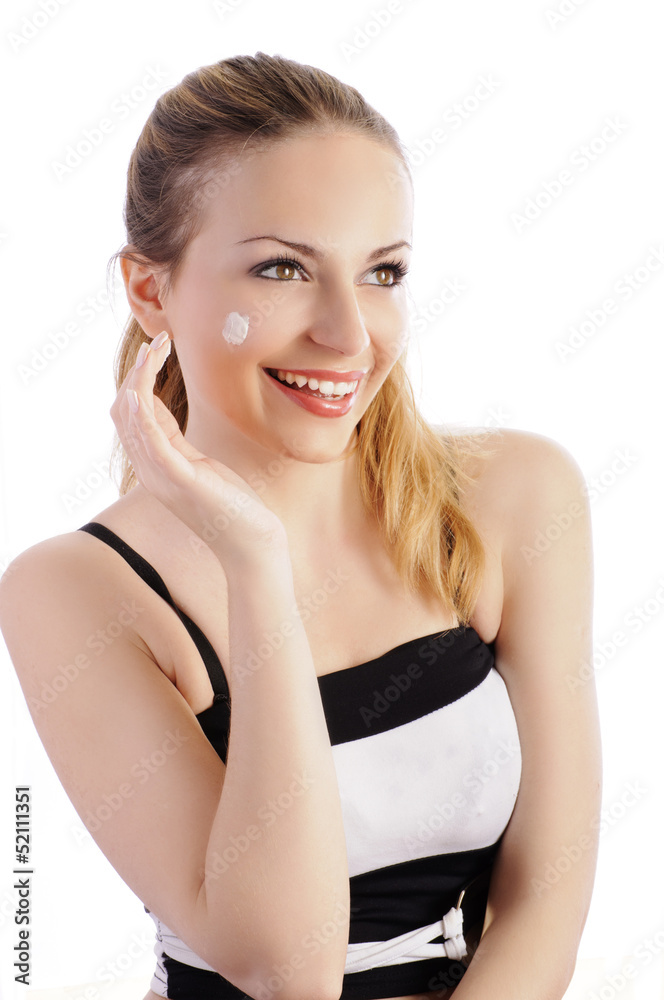 Pretty young woman applying face cream Pretty young woman applying face cream
