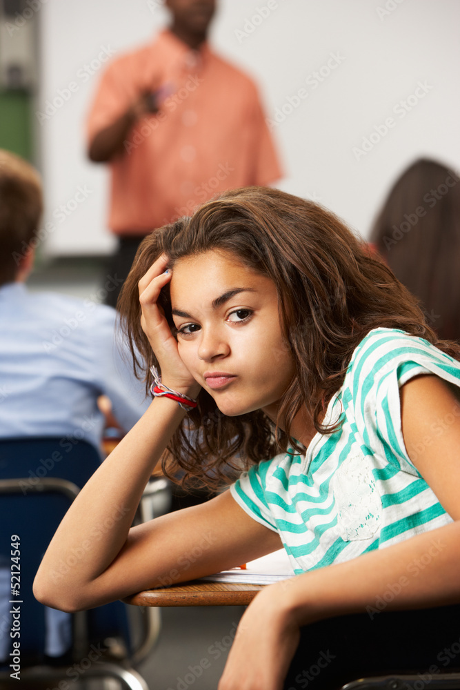 Fototapeta premium Bored Female Teenage Pupil In Classroom