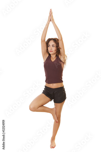 Fit Latin woman performs a yoga move.