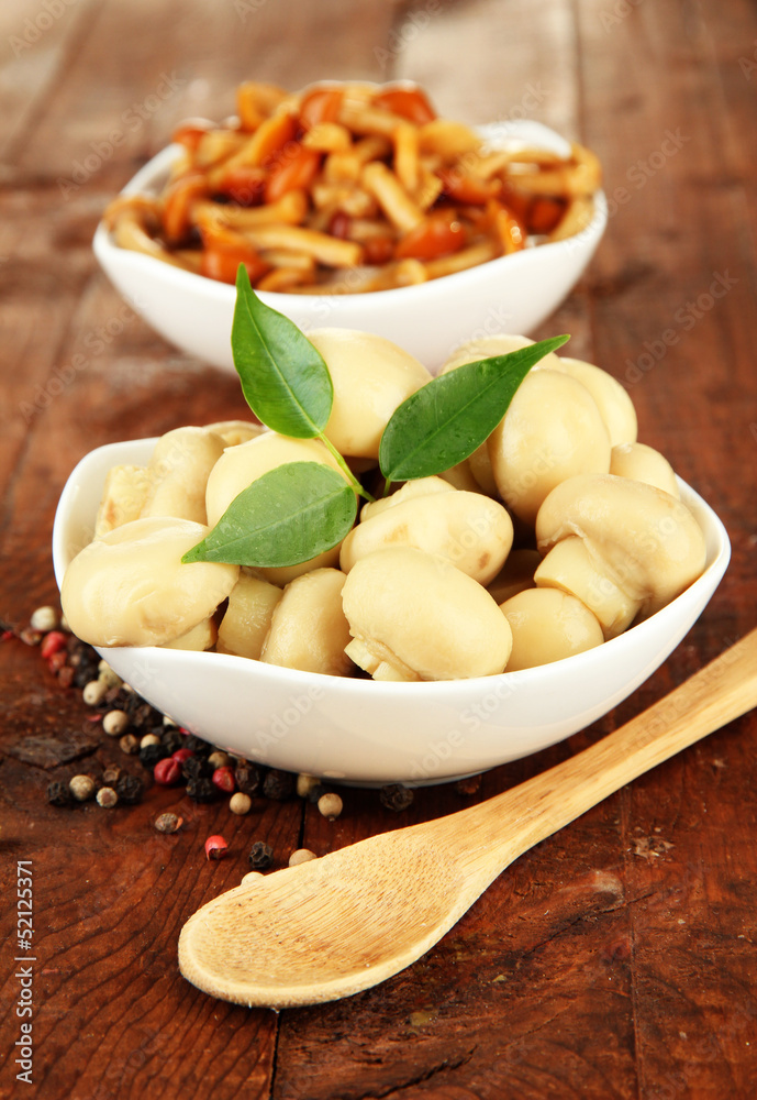 Mushrooms in bowls, on wooden background Mushrooms in bowls, on wooden background
