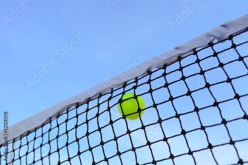 Closeup tennis net and ball with blue sky