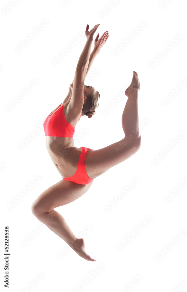 Slender young gymnast posing in jump