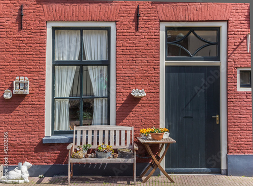 Red house with a bench photo