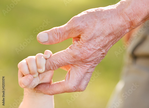 old man and a kid holding hands together