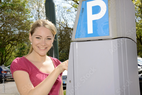 Junge Frau bedient Parkscheinautomaten photo