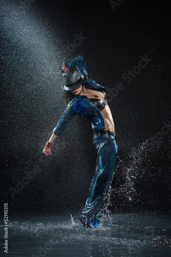 Wet dancing woman. Under waterdrops. Studio photo