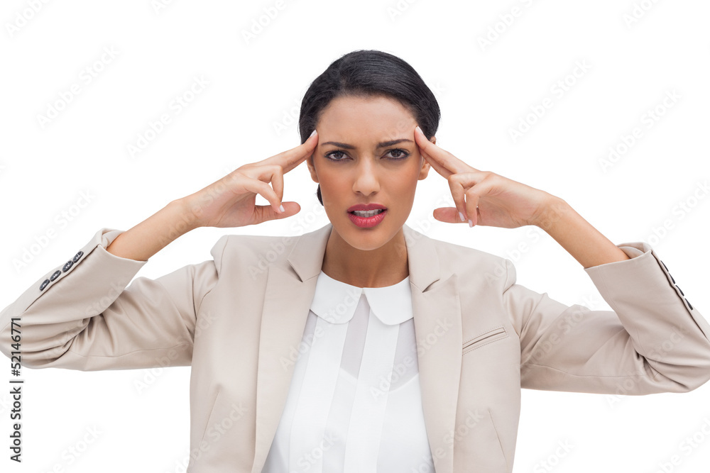 Concentrated businesswoman putting her fingers on her temples Concentrated businesswoman putting her fingers on her temples