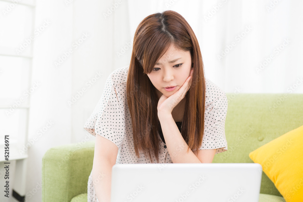 部屋でパソコンを使う女性