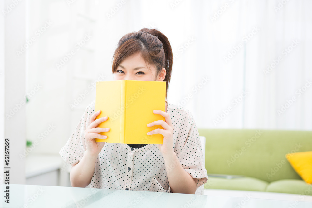 部屋で本を読む女性