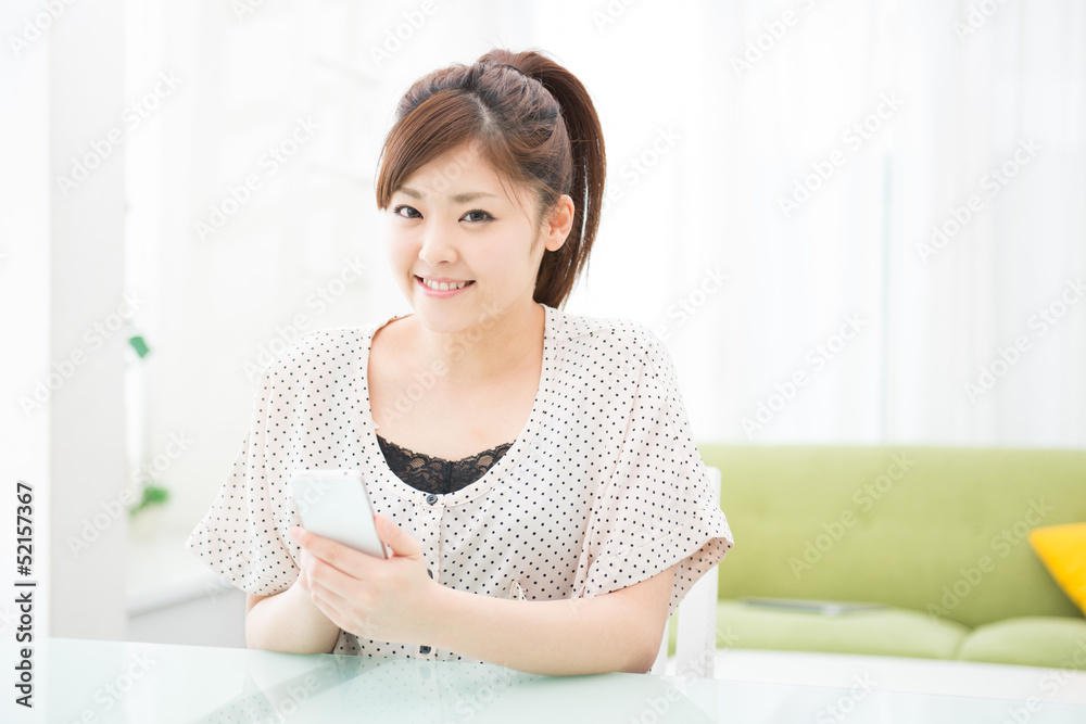 部屋でスマホを使う女性 部屋でスマホを使う女性