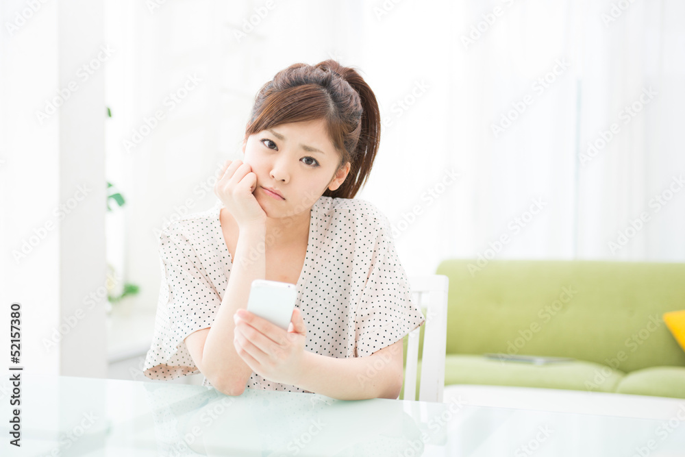 部屋でスマホを使う女性 部屋でスマホを使う女性
