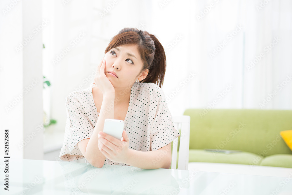 部屋でスマホを使う女性 部屋でスマホを使う女性