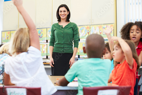 Teacher Talking To Elementary Pupils In Classroom