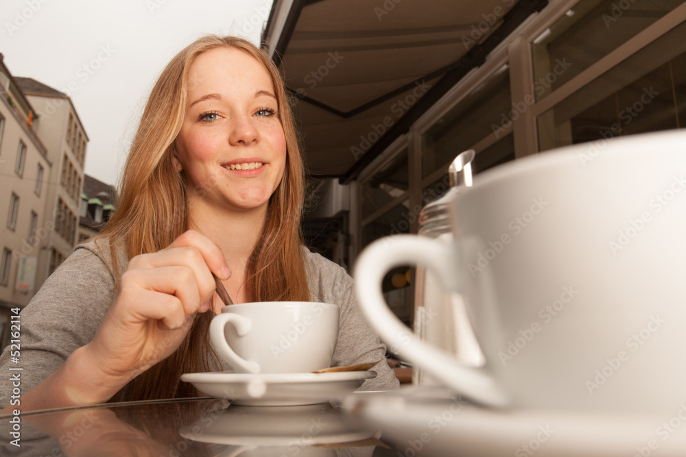 Junge Dame rührt Kaffee / Tee um Junge Dame rührt Kaffee / Tee um