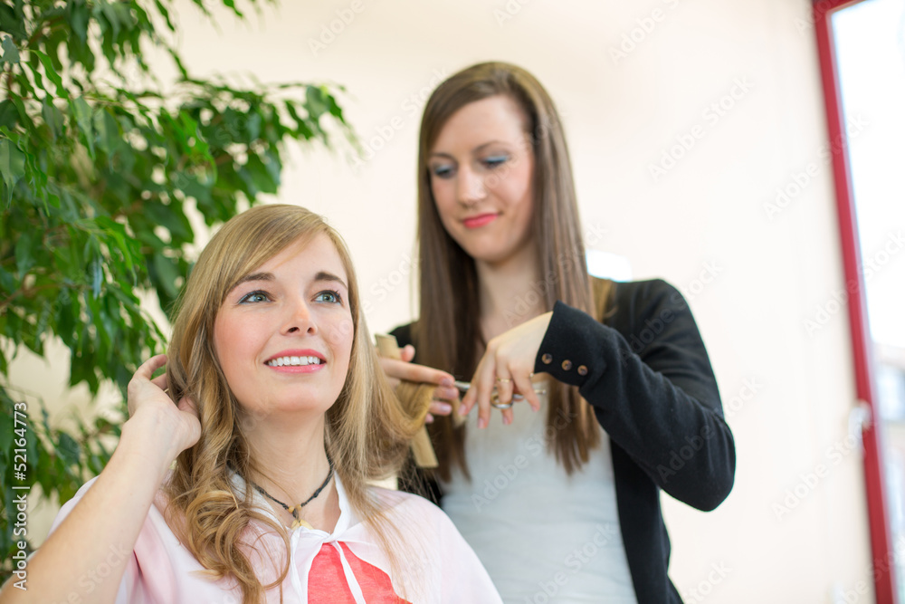 Hairdresser cutting customers hair in salon
