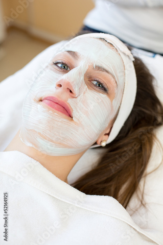 Cosmetician giving client facial skincare mask