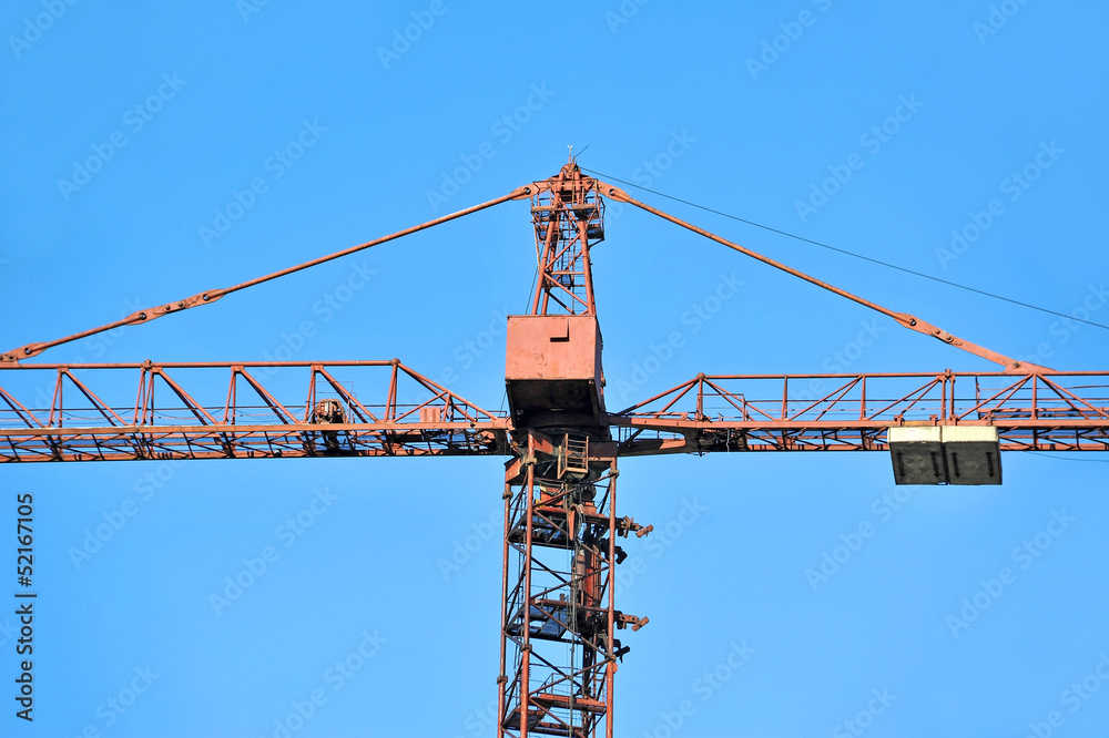 Red construction tower crane against blue sky Red construction tower crane against blue sky