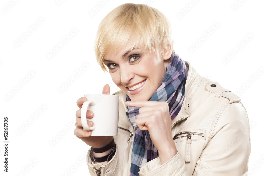 smiling pretty blonde pointing a finger in a cup of tea smiling pretty blonde pointing a finger in a cup of tea