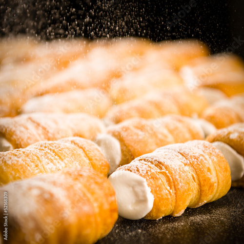 Powder sugar falling on to cream horns photo