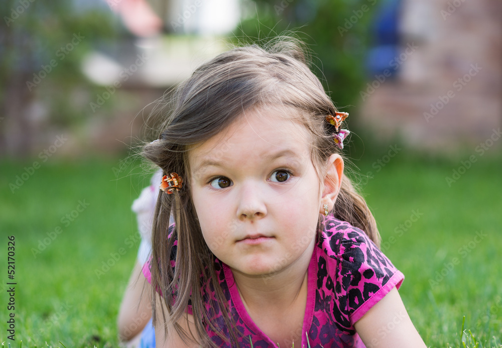 little girl laying down on grass little girl laying down on grass