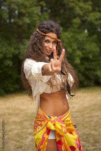 Beautiful hippie girl in the park making the sign of peace
