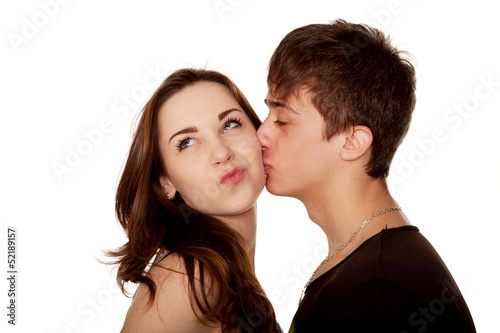 Teenage boy kissing girl. A girl grimacing