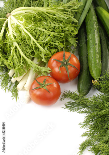 cucumbers and red tomato and green fresh vegetables leaves
