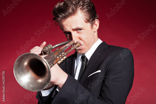 Retro fifties trumpet player wearing black suit. Playing trumpet