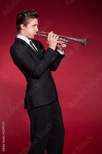 Retro fifties trumpet player wearing black suit. Playing trumpet