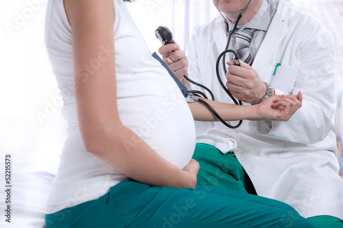 doctor measures the pressure of a pregnant woman