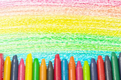 Colorful crayons and drawing of the rainbow.