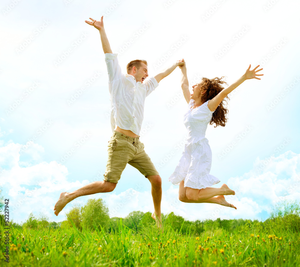 Happy Couple Outdoor. Jumping Family on Green Field Happy Couple Outdoor. Jumping Family on Green Field