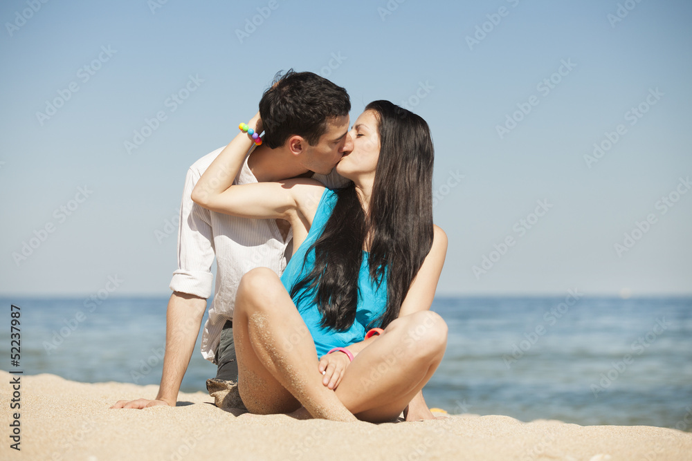 Beautiful couple kissing on the beach. Beautiful couple kissing on the beach.