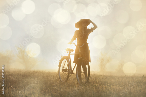 Girl on a bike in the countryside in sunrise time #52237978