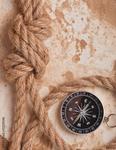 knot, a compass and a paper on the background of old paper