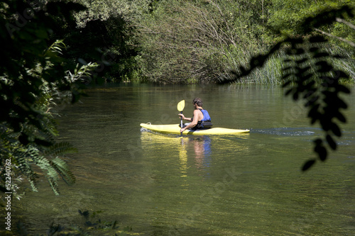 Young adult man kayaking down the river Cetina in Croatia