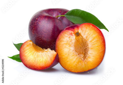 Fototapeta Ripe purple plum fruits with green leaves isolated