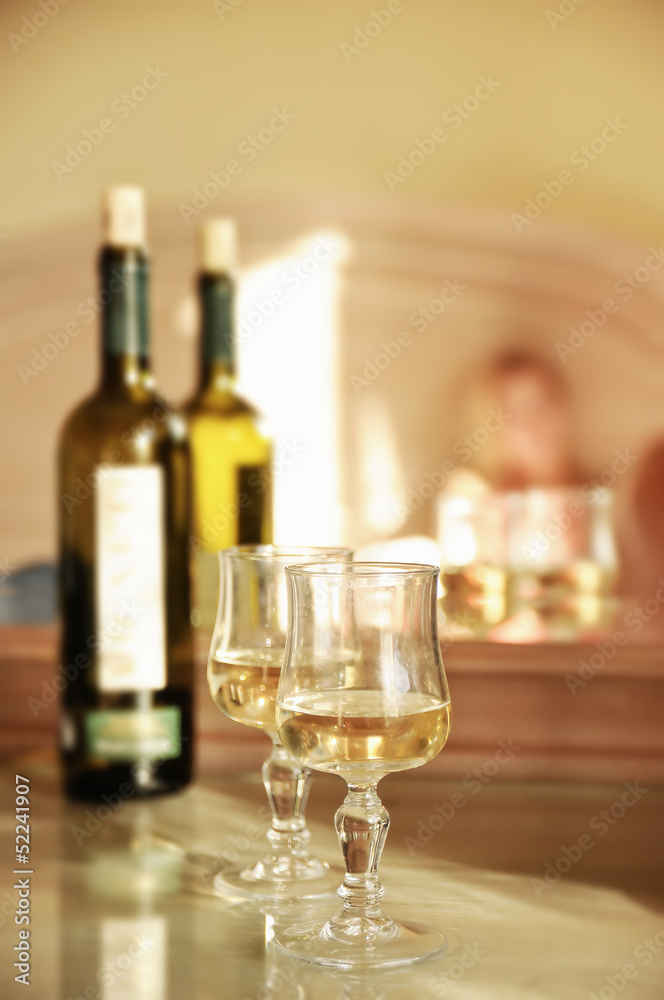 Glass of white wine and a bottle on the table
