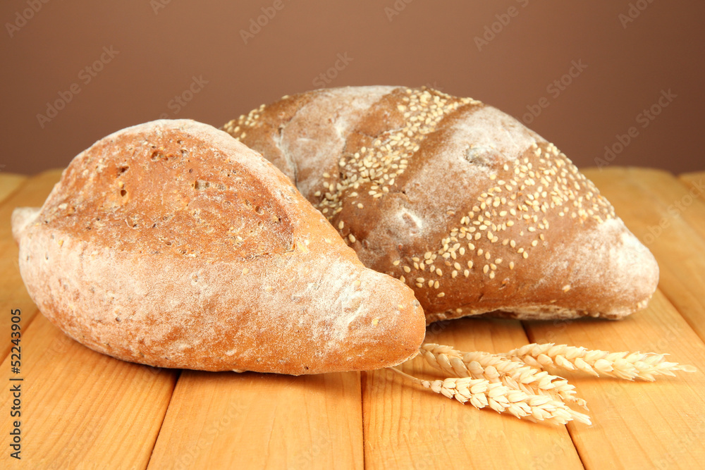 Composition with bread on wooden table, on color background