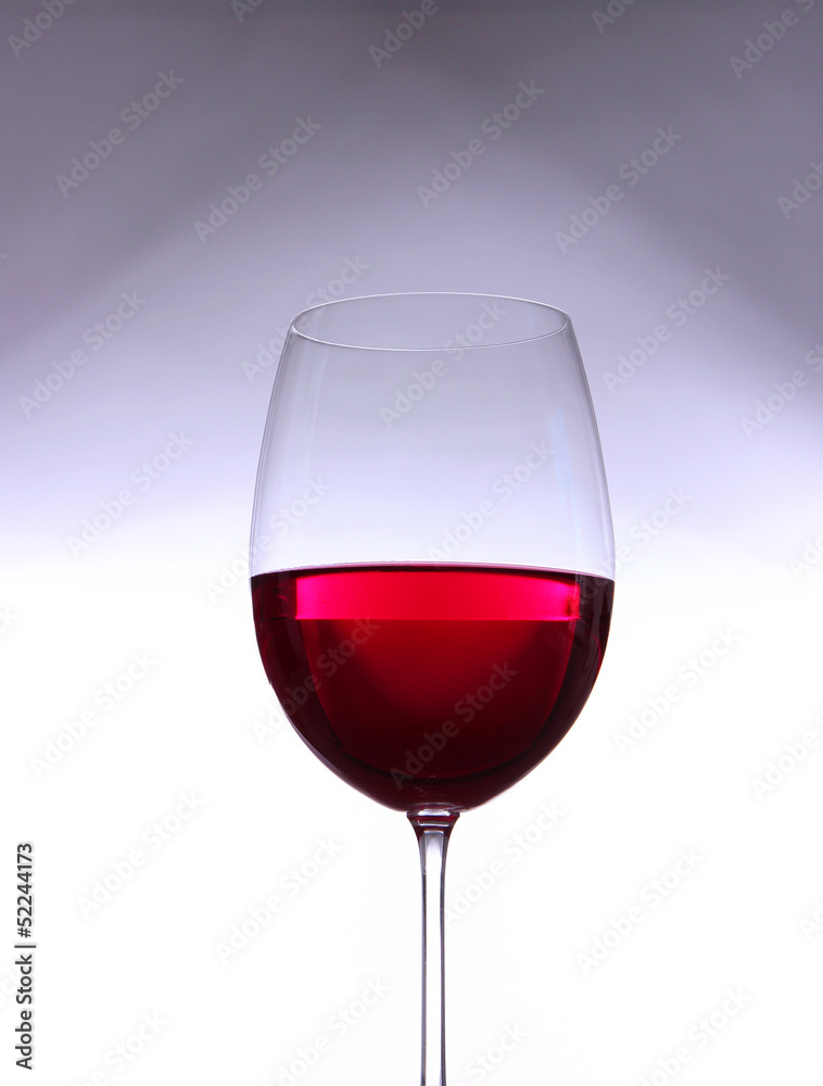 Glass with red wine on gray-white gradient background Glass with red wine on gray-white gradient background