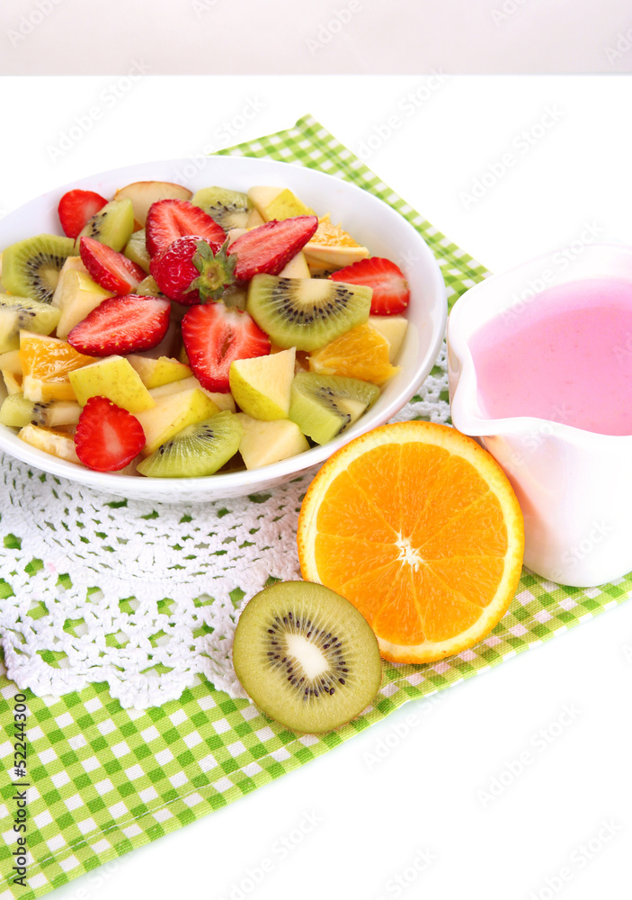 Useful fruit salad of fresh fruits and berries in bowl isolated