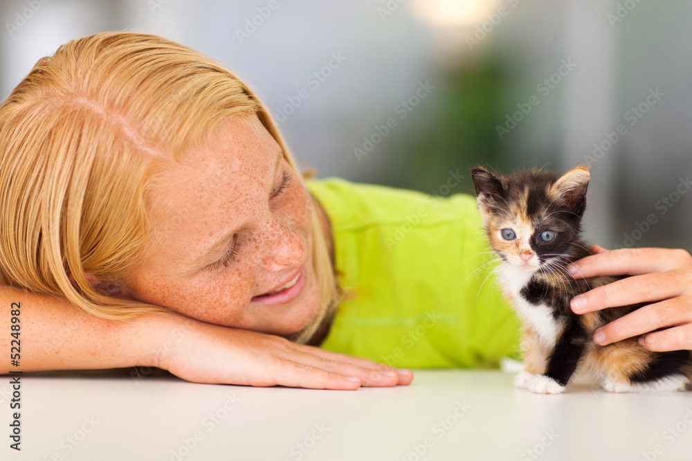 loving pre teen girl playing with kitten