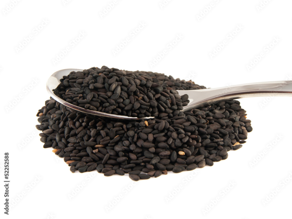 Sesame seeds on the spoon isolated on white Sesame seeds on the spoon isolated on white