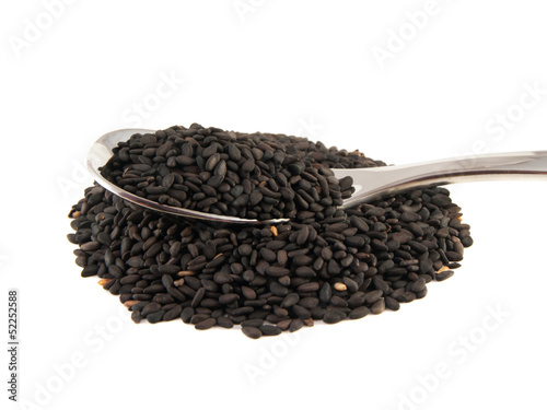Sesame seeds on the spoon isolated on white