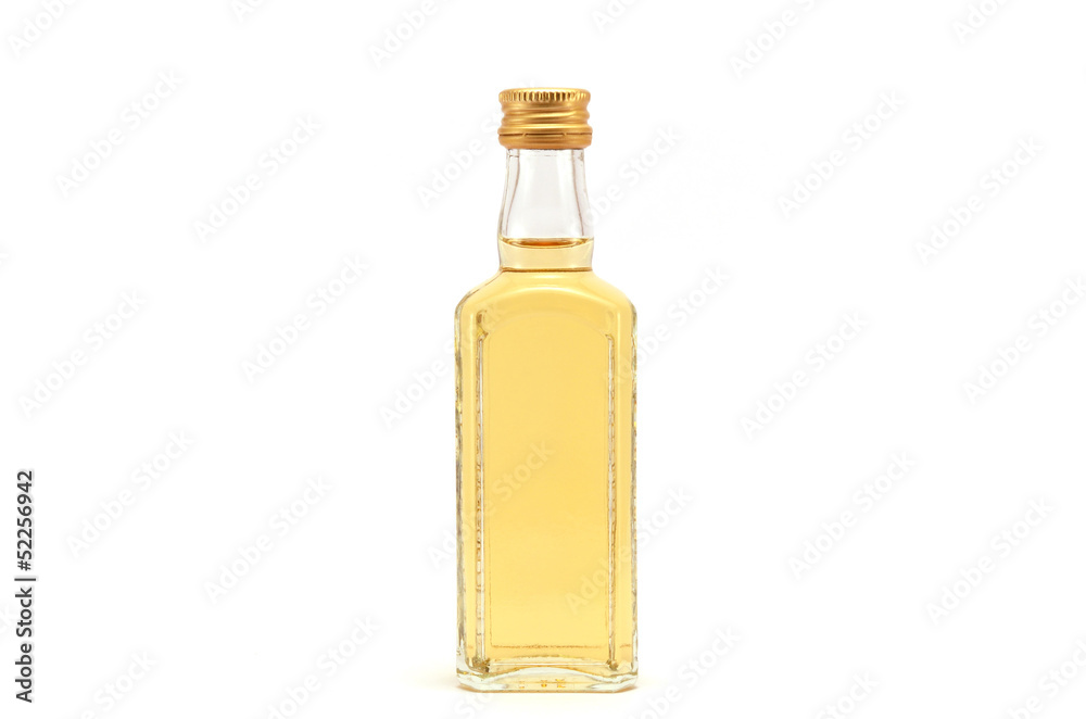 a glass bottle filled with liquid yellow in color