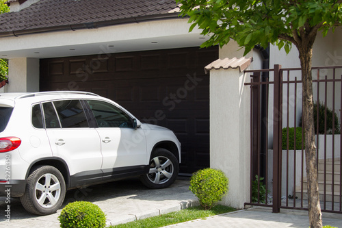 White car in front of the house waiting to enter in the garage photo